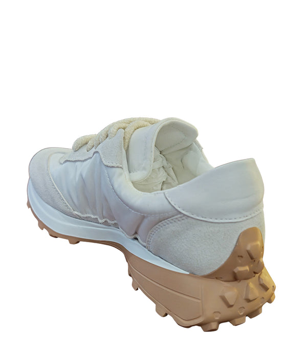 Handcrafted low-top sneaker made in Italy, featuring mixed-material construction with a star-shaped side detail, textured sole, and cushioned laces. Presented from multiple angles against a clean background.