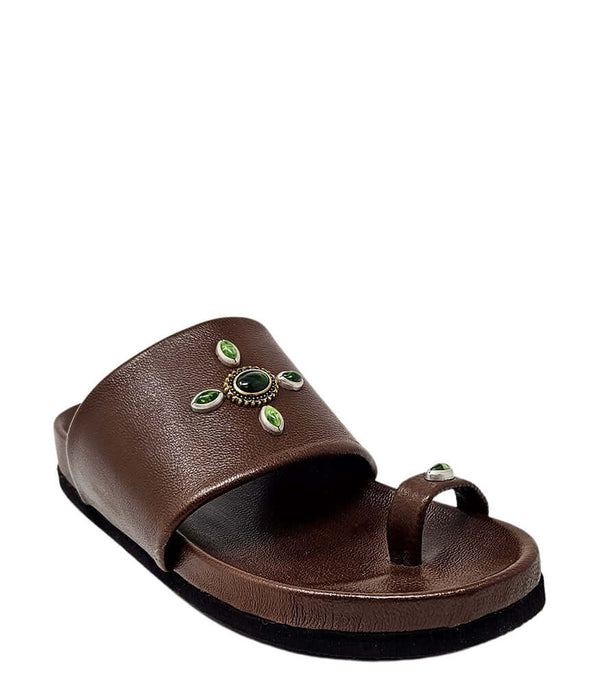 Open-toe flat sandal with a wide front strap and toe loop, embellished with central and side-set decorative stones. Features a contoured footbed and a low-profile sole.