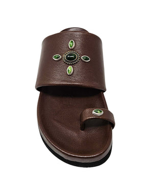 Open-toe flat sandal with a wide front strap and toe loop, embellished with central and side-set decorative stones. Features a contoured footbed and a low-profile sole.