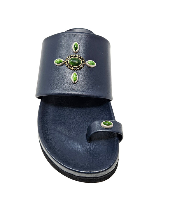 Open-toe flat sandal with a wide front strap and toe loop, embellished with central and side-set decorative stones. Features a contoured footbed and a low-profile sole.