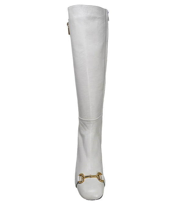 A tall leather boot with a block heel and rounded toe, featuring a metal horsebit-style detail at the front and a small metal padlock accent near the top of the shaft. Designed by Madison in Beverly Hills and handcrafted in Italy
