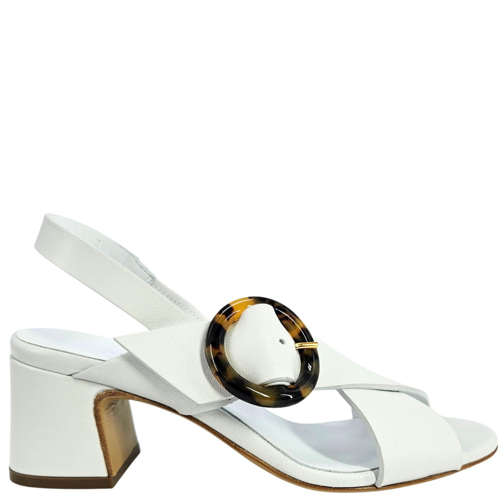 White sandal with a tortoiseshell ring on a white background