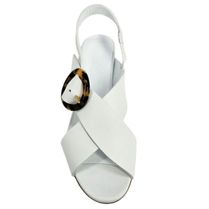 White sandal with a tortoiseshell buckle on a white background