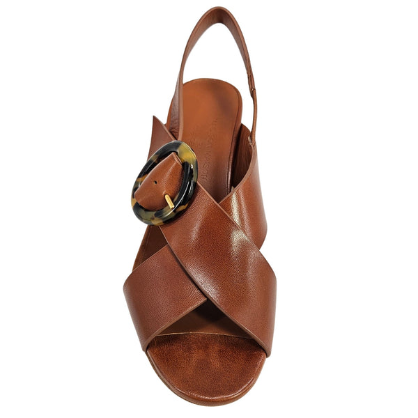 Brown sandal with a decorative buckle on a white background