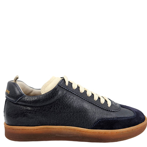 A navy blue leather and suede low-top sneaker with cream laces and a brown rubber sole.