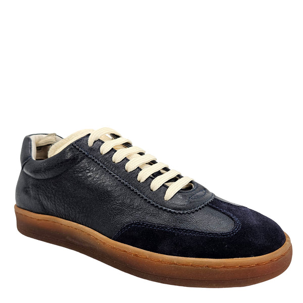 A navy blue leather and suede low-top sneaker with cream laces and a brown rubber sole.