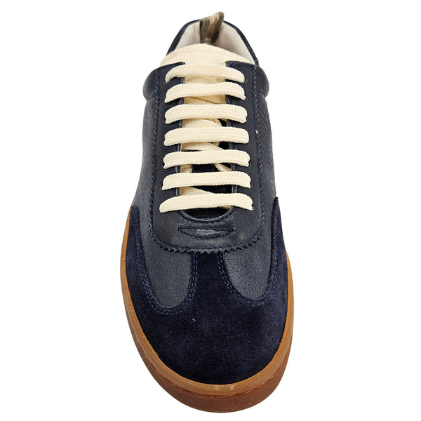 A navy blue leather and suede low-top sneaker with cream laces and a brown rubber sole.