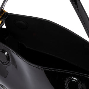 Close-up of a black leather handbag with a strap on a white background