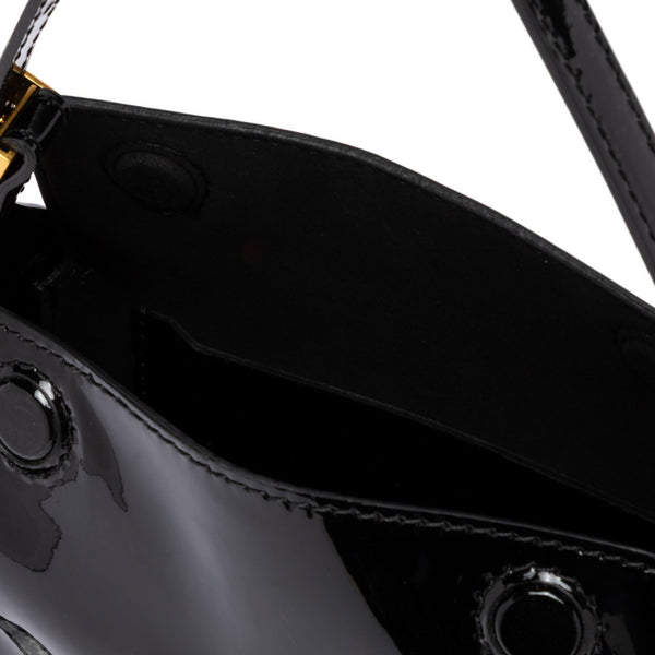 Close-up of a black leather handbag with a strap on a white background