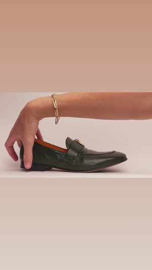 leather loafer with a rounded toe and flat sole, featuring a metal horsebit-style detail across the front. Designed by Madison in Beverly Hills and handcrafted in Italy.