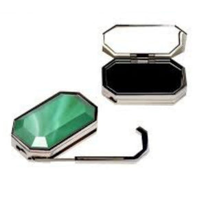 Two compact mirrors, one green and one black, on a white background
