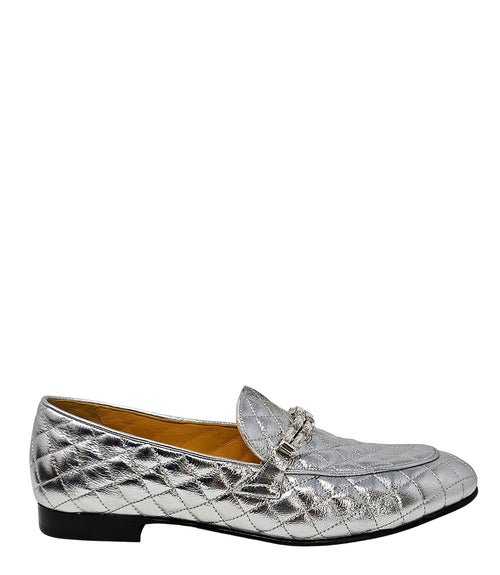 A quilted leather flat loafer with a low stacked heel and rounded toe, featuring a decorative strap adorned with rectangular gemstone-style embellishments. Designed by Madison in Beverly Hills and handcrafted in Italy.