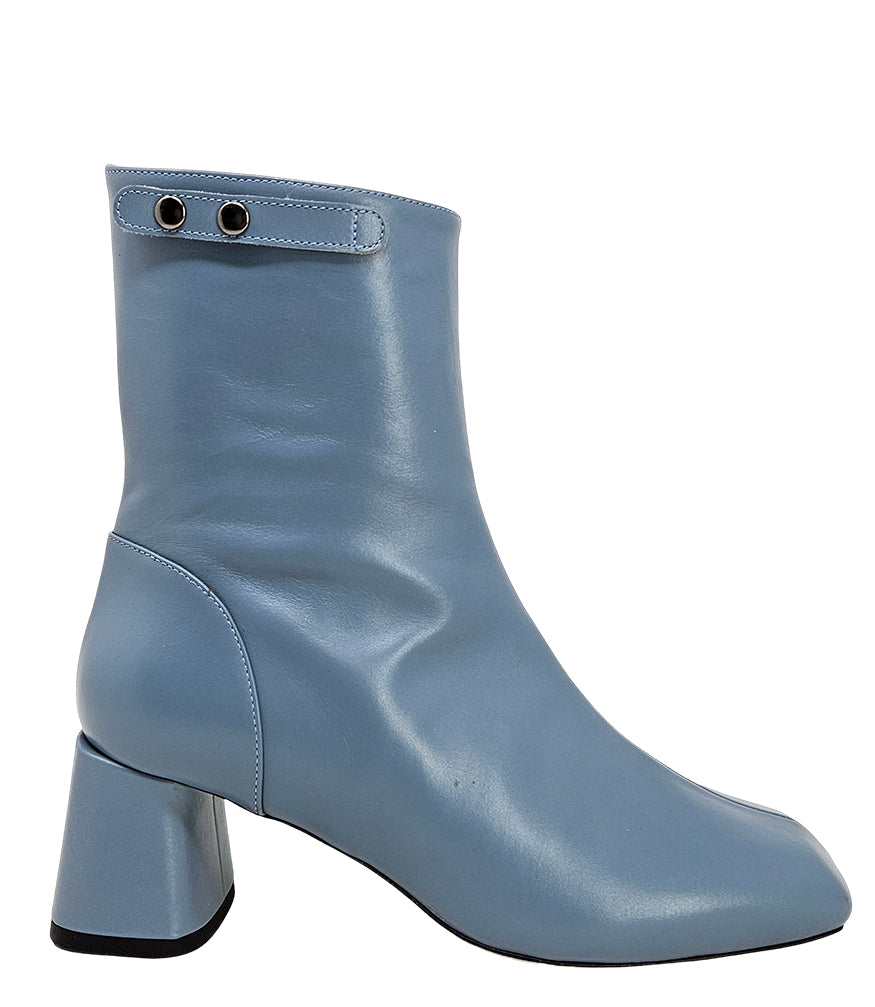 Handcrafted ankle boot made in Italy, designed with a smooth leather finish, square toe, side zipper closure, and a flared block heel. Features a decorative strap with metal accents. Shown from multiple angles against a clean background