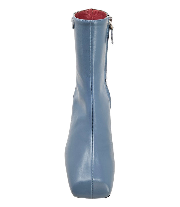 Handcrafted ankle boot made in Italy, designed with a smooth leather finish, square toe, side zipper closure, and a flared block heel. Features a decorative strap with metal accents. Shown from multiple angles against a clean background