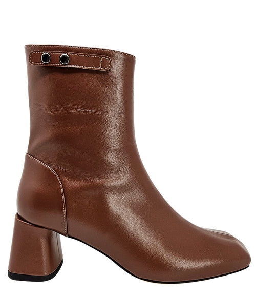 Handcrafted ankle boot made in Italy, designed with a smooth leather finish, square toe, side zipper closure, and a flared block heel. Features a decorative strap with metal accents. Shown from multiple angles against a clean background