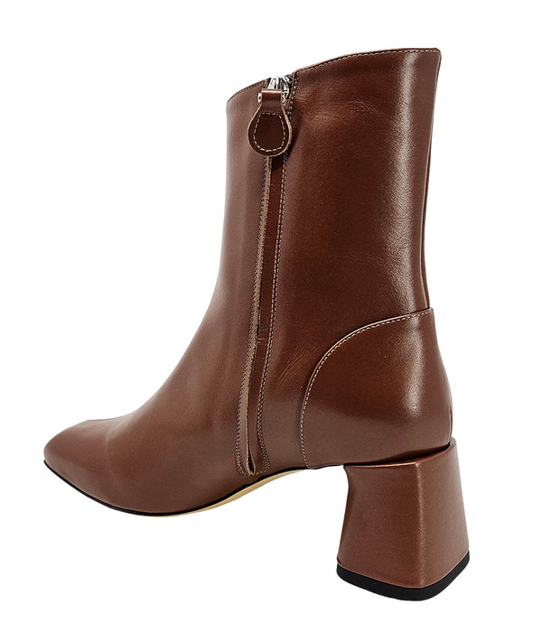 Handcrafted ankle boot made in Italy, designed with a smooth leather finish, square toe, side zipper closure, and a flared block heel. Features a decorative strap with metal accents. Shown from multiple angles against a clean background