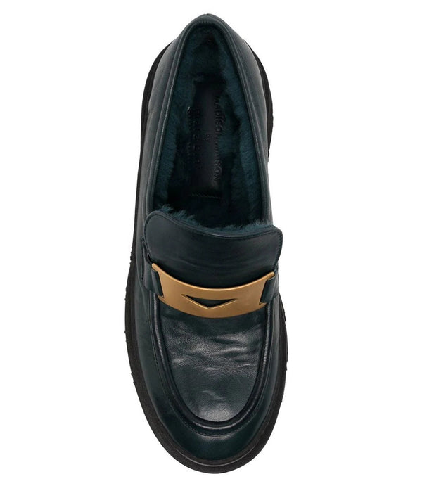 A leather loafer with an exaggerated lug sole and low-cut silhouette, featuring a wide strap with a geometric metal detail across the upper. Designed by Madison in Beverly Hills and handcrafted in Italy.