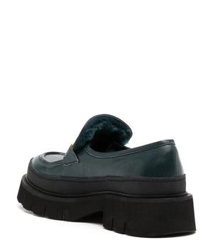 A leather loafer with an exaggerated lug sole and low-cut silhouette, featuring a wide strap with a geometric metal detail across the upper. Designed by Madison in Beverly Hills and handcrafted in Italy.