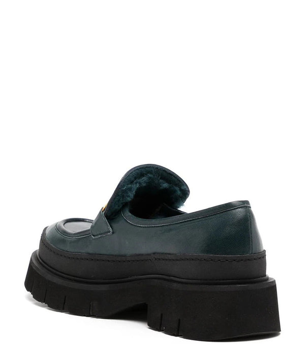 A leather loafer with an exaggerated lug sole and low-cut silhouette, featuring a wide strap with a geometric metal detail across the upper. Designed by Madison in Beverly Hills and handcrafted in Italy.