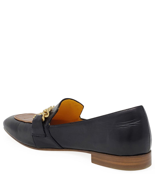A leather loafer with a flat sole and rounded toe, featuring a contrasting vamp panel and dual chain accents across the upper. Designed by Madison in Beverly Hills and handcrafted in Italy.