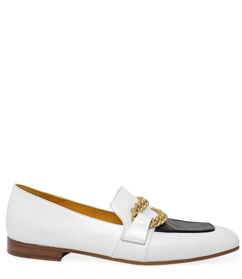 A leather loafer with a flat sole and rounded toe, featuring a contrasting vamp panel and dual chain accents across the upper. Designed by Madison in Beverly Hills and handcrafted in Italy.
