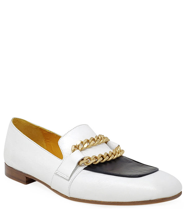 A leather loafer with a flat sole and rounded toe, featuring a contrasting vamp panel and dual chain accents across the upper. Designed by Madison in Beverly Hills and handcrafted in Italy.