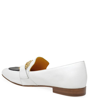 A leather loafer with a flat sole and rounded toe, featuring a contrasting vamp panel and dual chain accents across the upper. Designed by Madison in Beverly Hills and handcrafted in Italy.