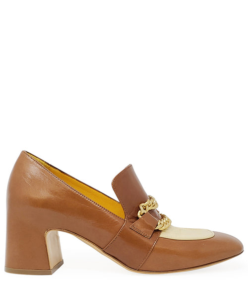 A leather heeled loafer with a block heel and rounded toe, featuring layered chain accents across the upper and a contrasting panel on the vamp. Designed by Madison in Beverly Hills and handcrafted in Italy.