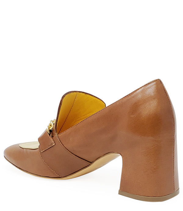 A leather heeled loafer with a block heel and rounded toe, featuring layered chain accents across the upper and a contrasting panel on the vamp. Designed by Madison in Beverly Hills and handcrafted in Italy.