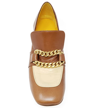 A leather heeled loafer with a block heel and rounded toe, featuring layered chain accents across the upper and a contrasting panel on the vamp. Designed by Madison in Beverly Hills and handcrafted in Italy.