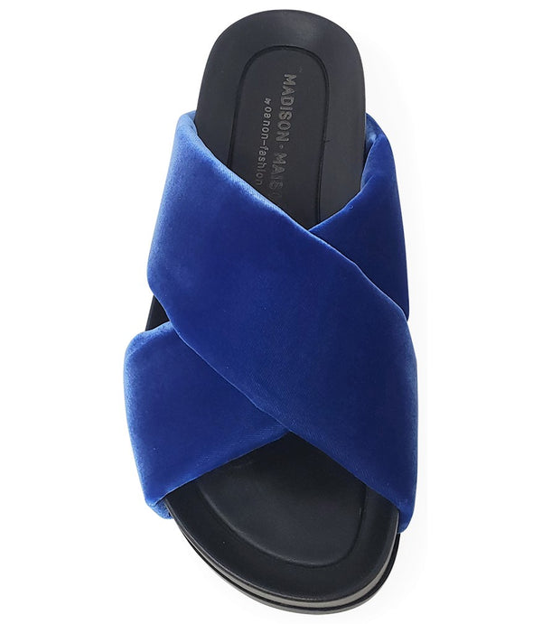 A handcrafted Italian open-toe flat sandal featuring a wide strap with a centered oval gemstone surrounded by circular studs, set on a molded footbed with a low platform sole."