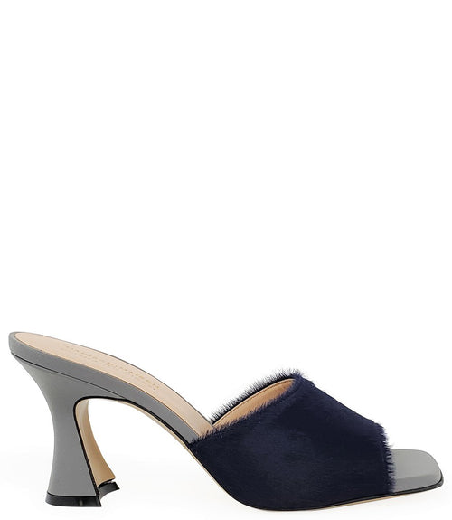 Handcrafted Italian mule with an open toe, flared heel, and a two-tone design. Features a wide vamp strap and cushioned insole for added comfort. Shown from multiple angles against a clean background