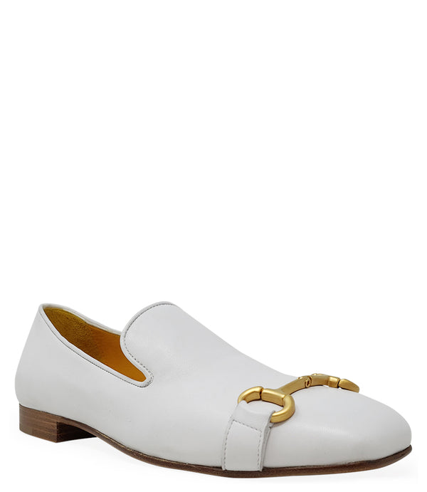 leather loafer with a rounded toe and flat sole, featuring a metal horsebit-style detail across the front. Designed by Madison in Beverly Hills and handcrafted in Italy.