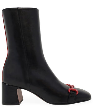 A mid-calf leather boot with a block heel and square toe, featuring a decorative metal accent across the toe. Designed by Madison in Beverly Hills and handcrafted in Italy.