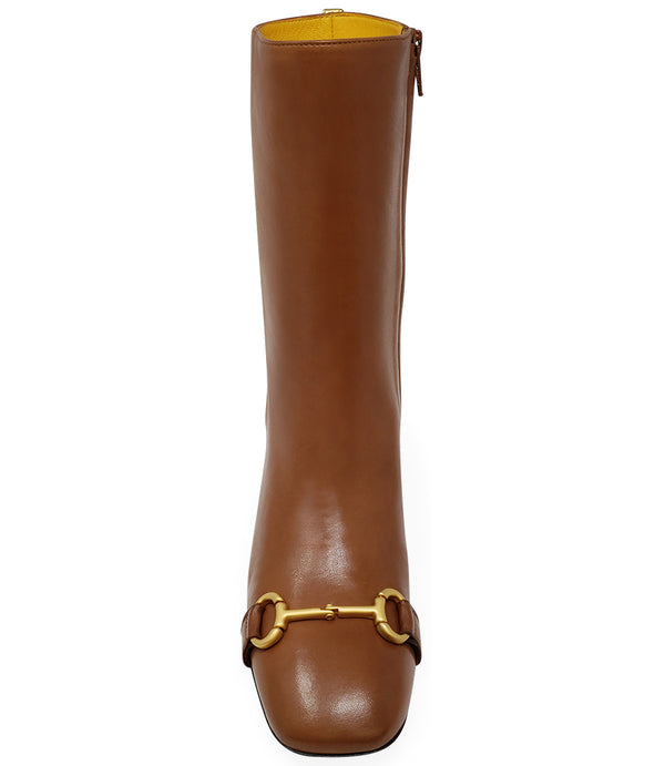 A mid-calf leather boot with a block heel and square toe, featuring a decorative metal accent across the toe. Designed by Madison in Beverly Hills and handcrafted in Italy.
