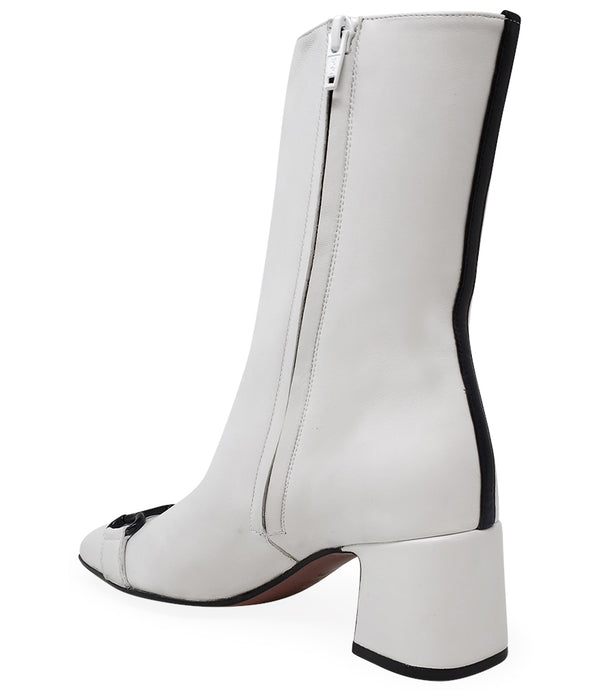 A mid-calf leather boot with a block heel and square toe, featuring a decorative metal accent across the toe. Designed by Madison in Beverly Hills and handcrafted in Italy.