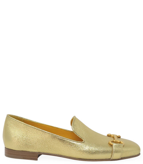 leather loafer with a rounded toe and flat sole, featuring a metal horsebit-style detail across the front. Designed by Madison in Beverly Hills and handcrafted in Italy.