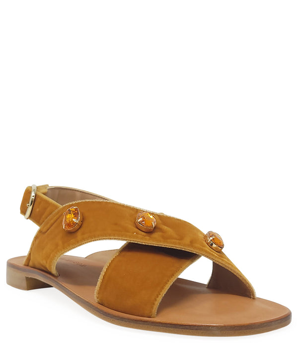 A handcrafted Italian open-toe flat sandal featuring a wide strap with a centered oval gemstone surrounded by circular studs, set on a molded footbed with a low platform sole."