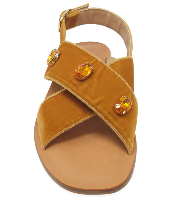 A handcrafted Italian open-toe flat sandal featuring a wide strap with a centered oval gemstone surrounded by circular studs, set on a molded footbed with a low platform sole."