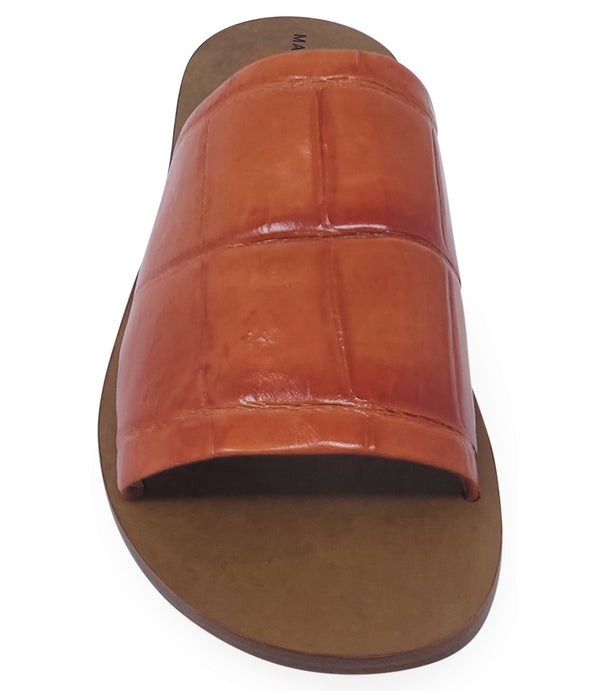 Handmade slide sandal crafted in Italy with a wide, textured band across the foot and a flat leather sole. Features a structured, embossed finish. Displayed from front and side angles against a clean background.
