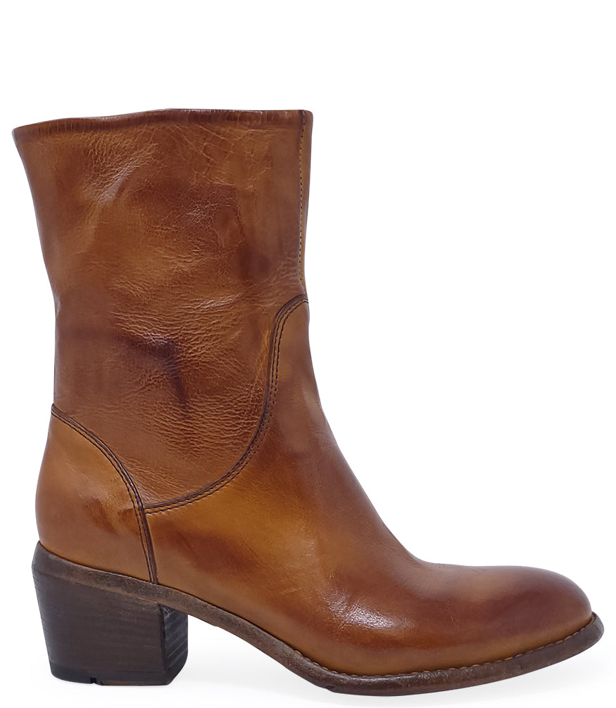 Mid-calf leather boot with rounded toe, block heel, and natural creasing for a worn-in effect. Features minimal seam detailing