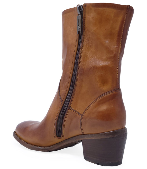Mid-calf leather boot with rounded toe, block heel, and natural creasing for a worn-in effect. Features minimal seam detailing