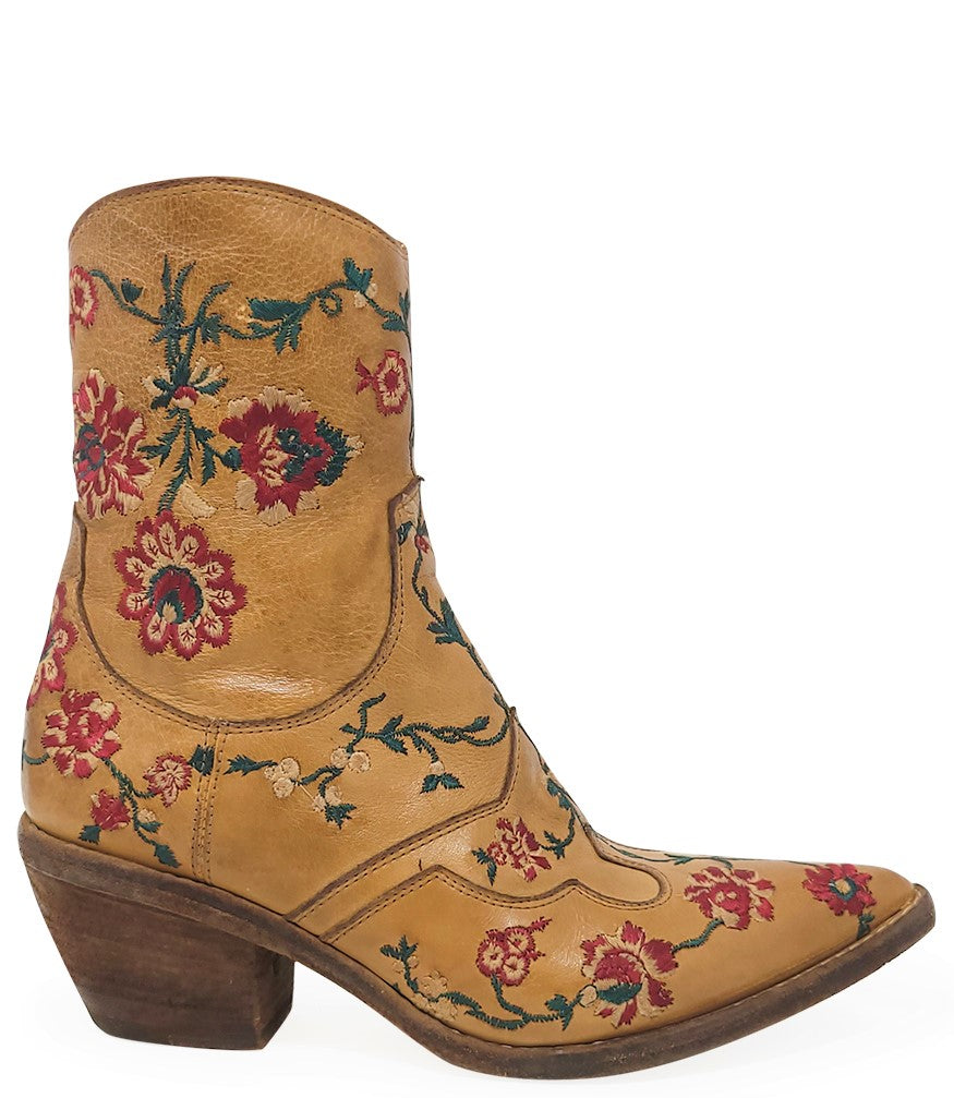 Western-style ankle boot featuring detailed floral embroidery, a pointed toe, side zipper, and angled block heel. Crafted with decorative stitching and a vintage finish.