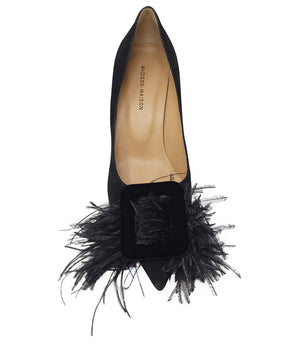 Pointed-toe pump crafted from soft suede with a mid-height stiletto heel, featuring a dramatic feather and velvet buckle embellishment across the toe. Designed with a leather-lined interior and a durable leather outsole for lasting comfort and support. El
