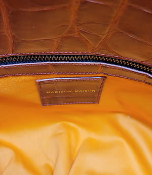 "Large hobo-style shoulder bag crafted from premium leather with an all-over crocodile-embossed texture. Features a wide, adjustable leather shoulder strap with metal hardware and an open top for easy access. Softly structured body designed for a relaxed