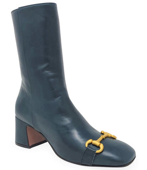 A mid-calf leather boot with a block heel and square toe, featuring a decorative metal accent across the toe. Designed by Madison in Beverly Hills and handcrafted in Italy.