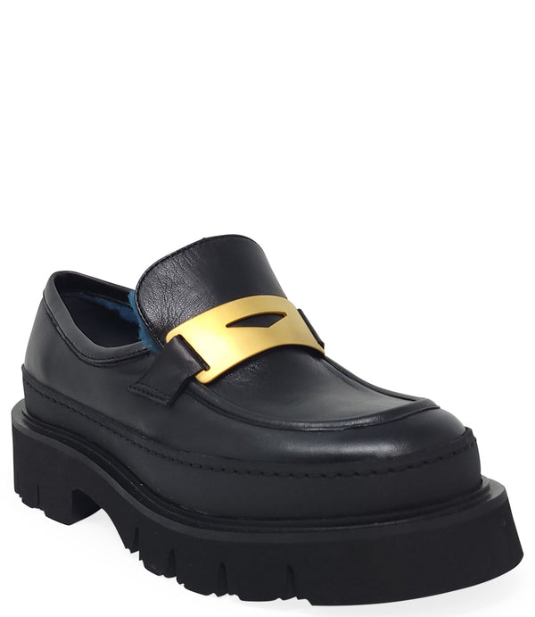 A leather loafer with an exaggerated lug sole and low-cut silhouette, featuring a wide strap with a geometric metal detail across the upper. Designed by Madison in Beverly Hills and handcrafted in Italy.