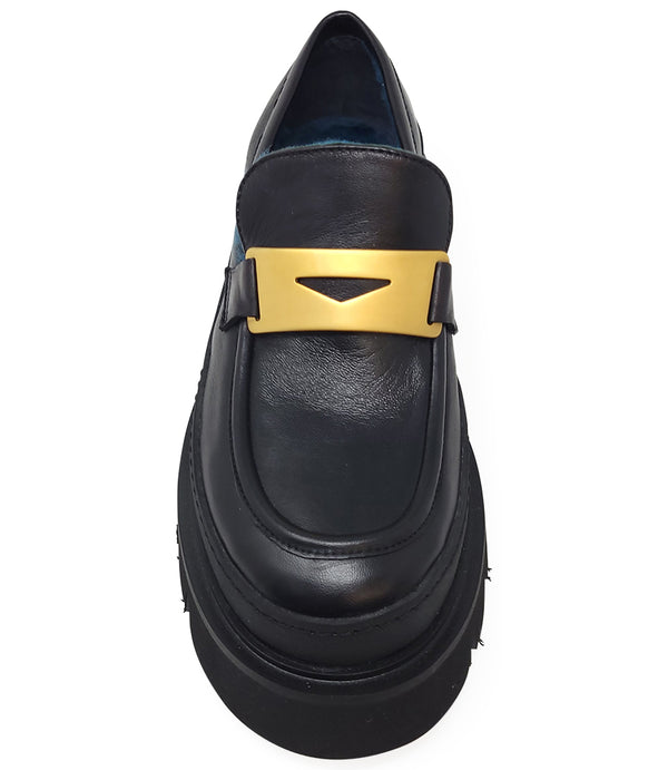 A leather loafer with an exaggerated lug sole and low-cut silhouette, featuring a wide strap with a geometric metal detail across the upper. Designed by Madison in Beverly Hills and handcrafted in Italy.