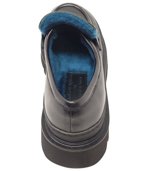 A leather loafer with an exaggerated lug sole and low-cut silhouette, featuring a wide strap with a geometric metal detail across the upper. Designed by Madison in Beverly Hills and handcrafted in Italy.