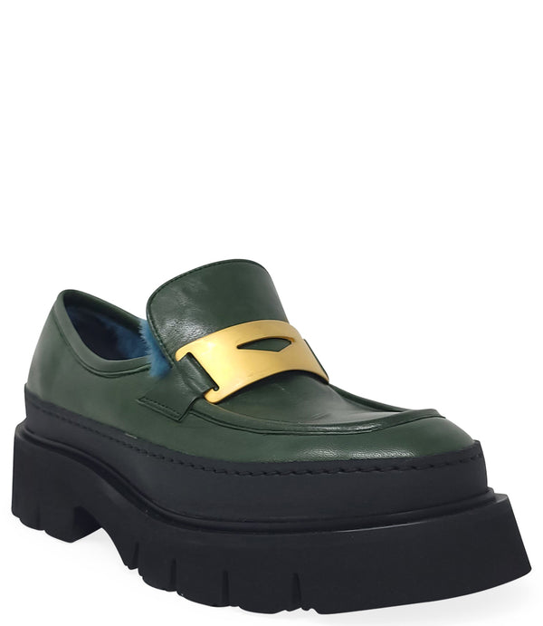 A leather loafer with an exaggerated lug sole and low-cut silhouette, featuring a wide strap with a geometric metal detail across the upper. Designed by Madison in Beverly Hills and handcrafted in Italy.